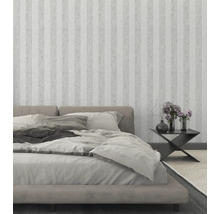 Schlafzimmer mit Bett, Nachttisch und gestreifter Tapete