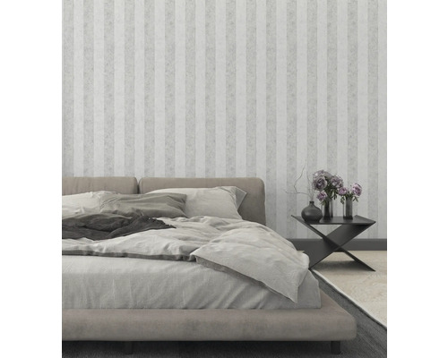 Schlafzimmer mit Bett, Nachttisch und gestreifter Tapete