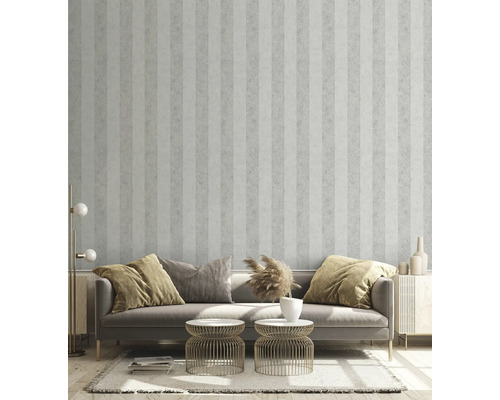 Wohnzimmer mit gestreifter Tapete, Sofa, Beistelltischen und dekorativen Elementen für ein stilvolles Ambiente.