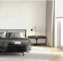 Helles Schlafzimmer mit Bett, Nachttisch und Teppich