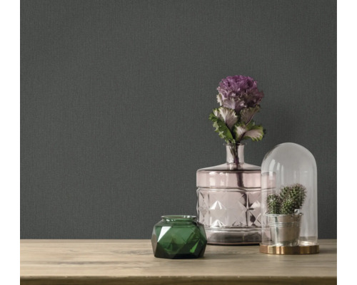 Dekorative Accessoires auf einem Tisch vor einer dunklen Tapete