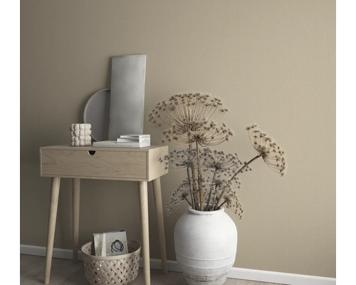 Dekoratives Arrangement mit Beistelltisch, Vase mit Trockenblumen und Dekorationselementen vor einer einfarbigen Wand.