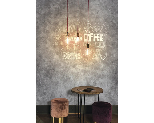 Dekorativer Raum mit Pendelleuchten, Wandkunst, Tisch und Hockern.