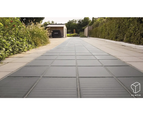 Außenbereich mit Lichtschachtabdeckung und Pflastersteinen