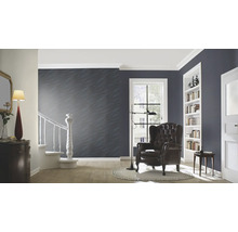 Wohnzimmer mit Sessel, Regal und Treppe in einem Haus