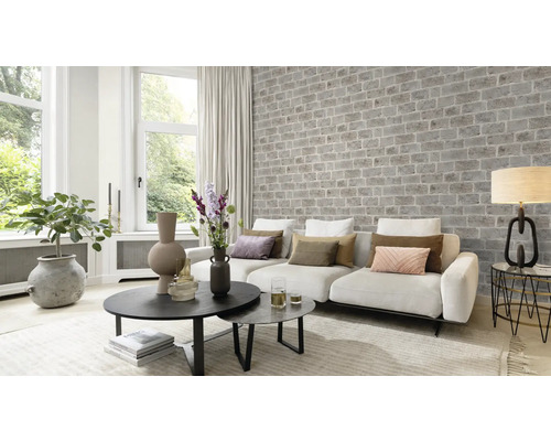 Wohnzimmer mit Couch, Tisch und Ziegelwand