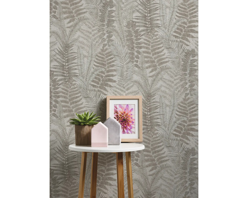 Zimmer mit Farnmuster-Tapete, Beistelltisch, Zimmerpflanze und Bilderrahmen