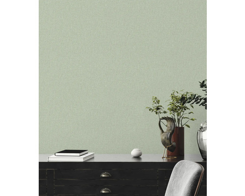 Helle, strukturierte Tapete in einem Wohnraum mit dunklen Möbeln und dekorativen Elementen.