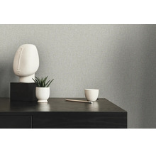 Nahaufnahme einer grauen Vliestapete mit minimalistischer Dekoration auf einem Tisch