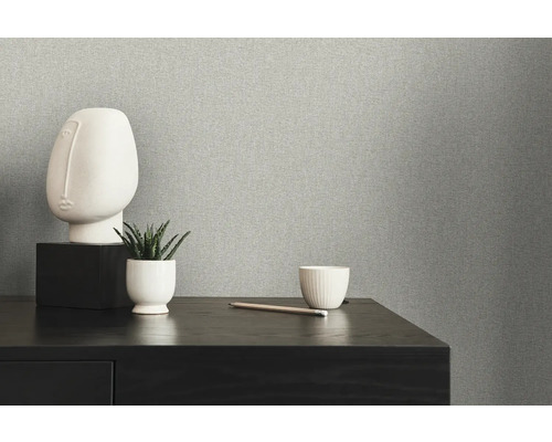 Nahaufnahme einer grauen Vliestapete mit minimalistischer Dekoration auf einem Tisch