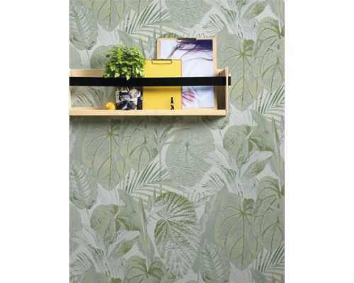 Regal mit Pflanze, Notizblöcken und Foto vor einer Tapete mit Blattmuster