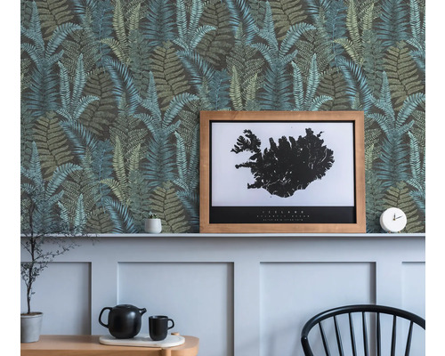 Dekorative Wand mit Farnmuster-Tapete, einem gerahmten Island-Poster und dekorativen Objekten