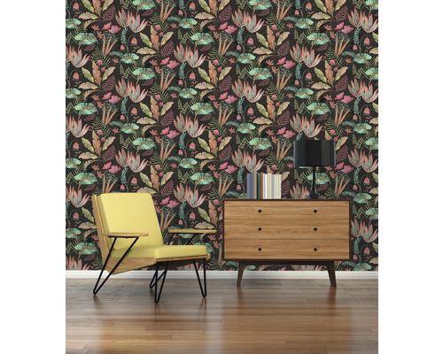 Wohnzimmer mit gelbem Sessel, Kommode, Lampe und floraler Tapete