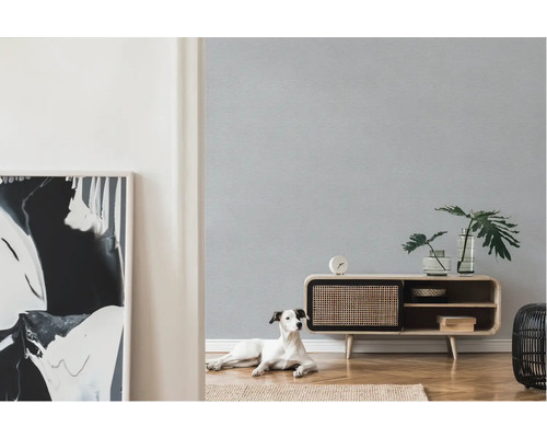 Heller Raum mit gemusterter Tapete, Sideboard, Zimmerpflanzen, Dekoration und Hund