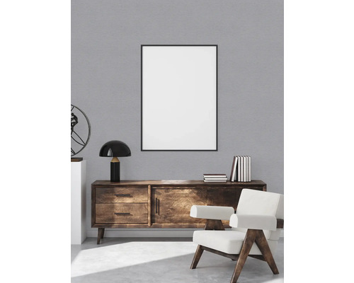 Wohnzimmer mit Holzkommode, Bilderrahmen und Sessel