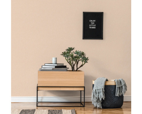 Helles Zimmer mit Holzfußboden, Kommode, Topfpflanze, Korb und Wanddekoration