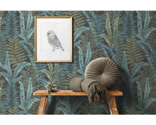 Szene mit Farnmuster-Tapete, einem gerahmten Vogelbild und Dekorationen auf einem Holztisch