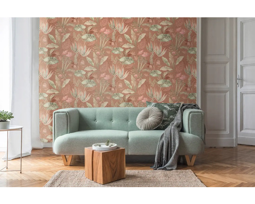 Wohnzimmer mit Couch und gemusterter Tapete mit Pflanzenmotiven