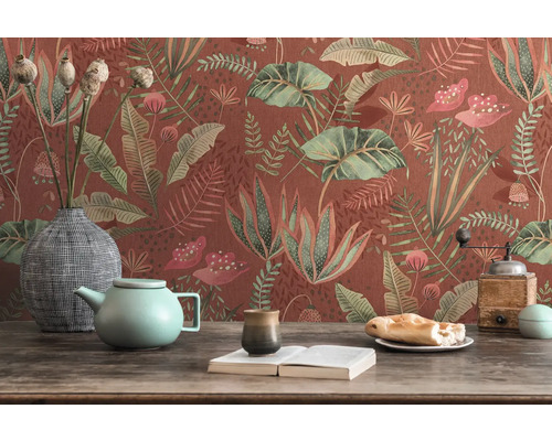 Dekoratives Stillleben mit floraler Tapete, Teekanne, Geschirr und Buch auf einem Tisch