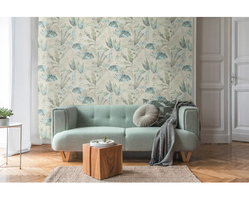 Zimmer mit Sofa und Dschungeltapete mit Pflanzenmotiven