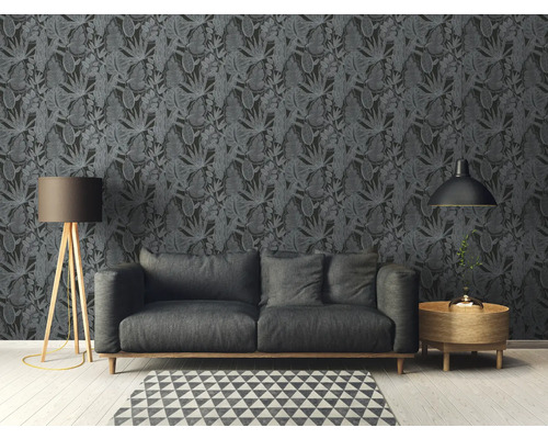 Wohnzimmer mit Sofa vor dunkler Blättertapete