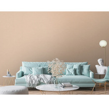 Wohnzimmer mit Sofa, Sessel, Dekoration und beiger Wandtapete.