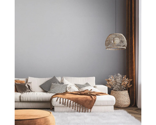 Helles Wohnzimmer mit Sofa, Kissen, Decke und Dekorationen in einem natürlichen Design