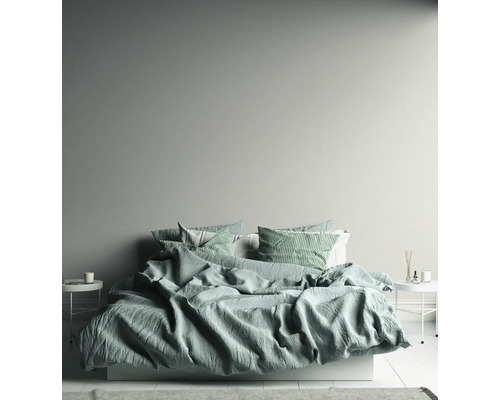 Helles Schlafzimmer mit Bett, Nachttischen und dekorativen Elementen.