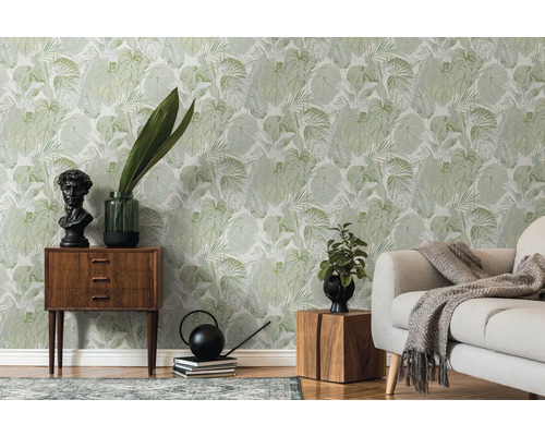 Wohnraum mit grüner Blättertapete, Sofa und Holzmöbeln