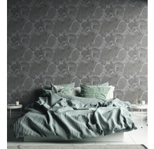 Schlafzimmer mit Bett und floral gemusterter Tapete