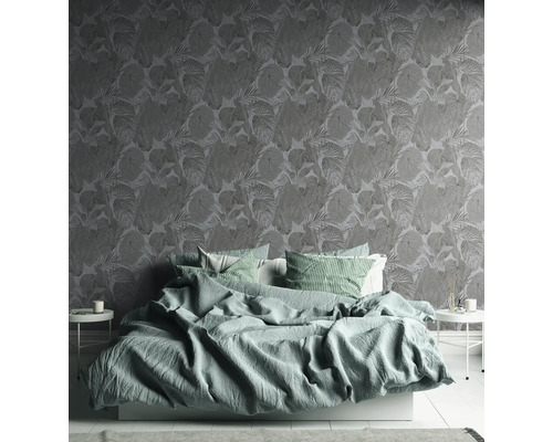 Schlafzimmer mit Bett und floral gemusterter Tapete