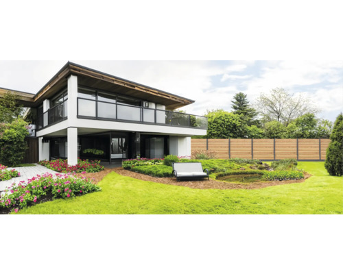 Modernes Haus mit Garten, Holzterrasse, Blumen und Holzzaun