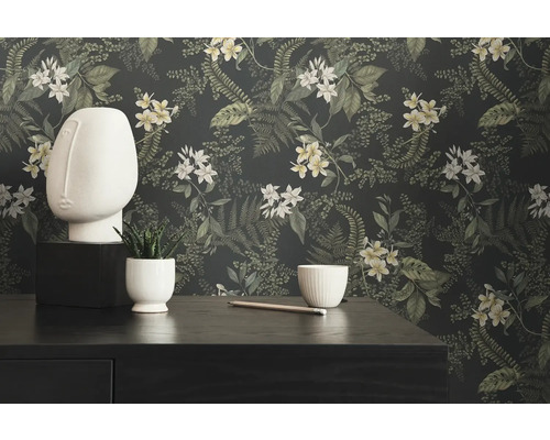 Dekoratives Stillleben mit Blumtapete, Skulptur und Pflanze auf Kommode