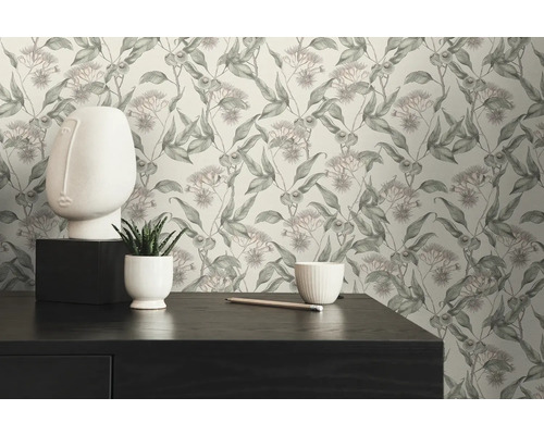 Szene mit einer Kommode, einer weißen Gesichtsskulptur und einer Tapete mit floralem Muster.