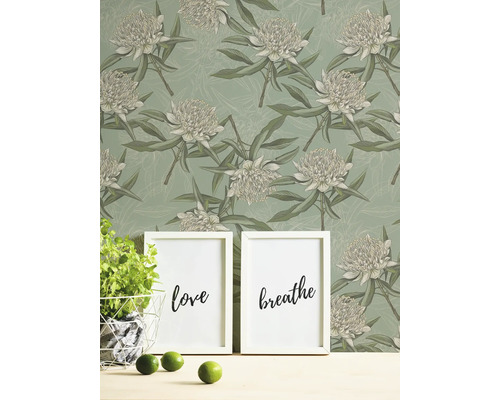 Blumentapete mit zwei Bilderrahmen, einem Topf Basilikum und Limetten