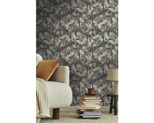 Szene mit einer Wandtapete mit Pflanzenmuster, einem Sofa und einem Stapel Büchern