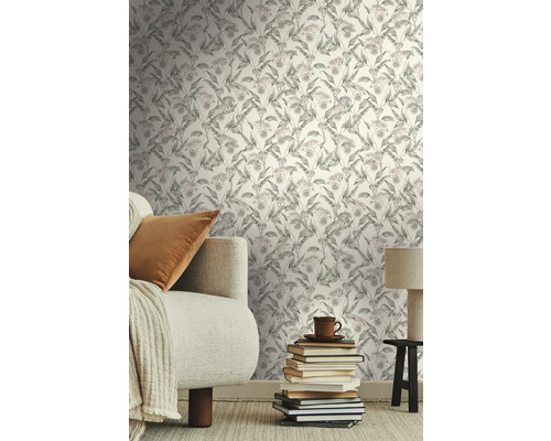 Wohnzimmer mit floraler Tapete, Sofa, Kissen und Bücherstapel als Dekoration