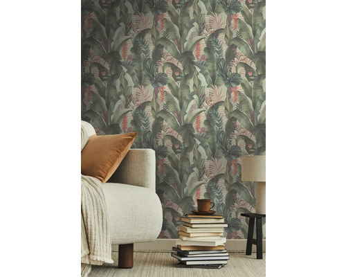 Wohnraum mit Dschungel-Tapete, Sofa und Bücherstapel