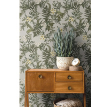 Zimmer mit botanischer Blumentapete, Holzkonsole und Topfpflanze.