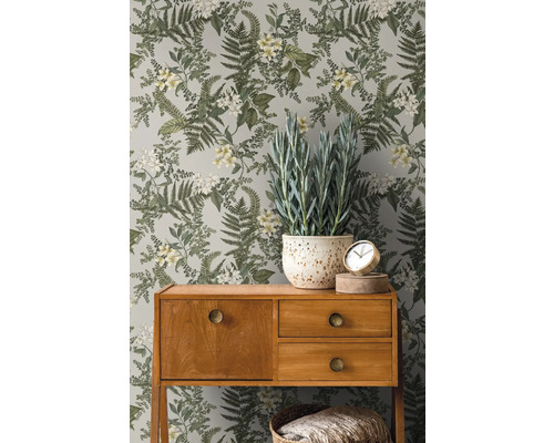 Zimmer mit botanischer Blumentapete, Holzkonsole und Topfpflanze.