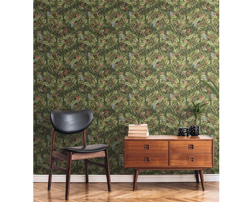 Szene mit Sessel, Kommode und Blättertapete im Wohnraum