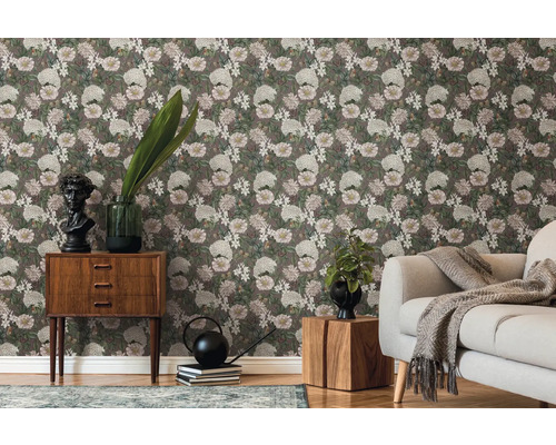 Wohnzimmer mit floraler Tapete, Sofa und Holzmöbeln