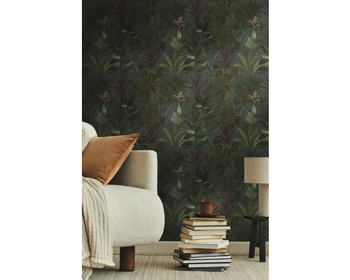 Wohnzimmer mit Dschungeltapete, Sofa, Tischlampe und Bücherstapel