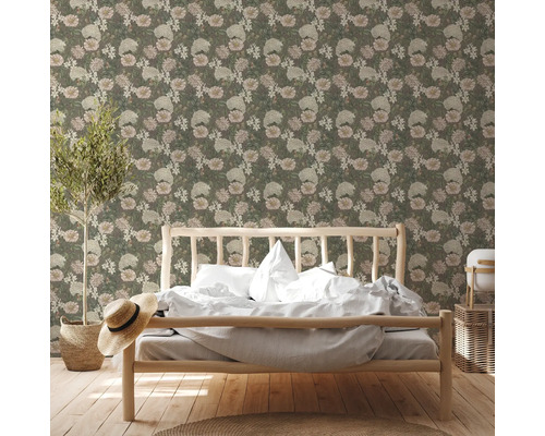 Schlafzimmer mit floral gemusterter Tapete, Bett aus Holz und Dekorationen.