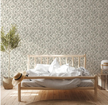 Schlafzimmer mit Bett und gemusterter Tapete mit Pflanzenmotiven