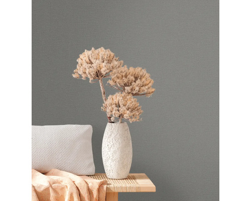 Nahaufnahme einer grauen Vliestapete mit floralem Arrangement auf einem Beistelltisch