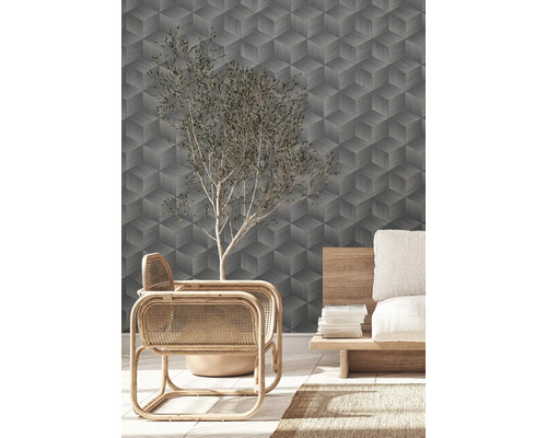 Wohnraum mit geometrischer Tapete, Sessel und Dekoration