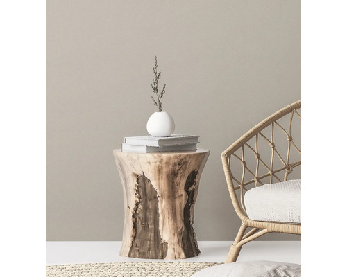 Dekorative Szene mit Holzhocker, Büchern, Vase und Korbsessel