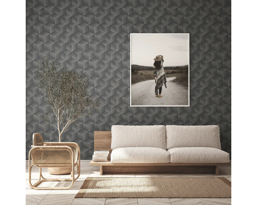 Wohnzimmer mit geometrischer Tapete, Sofa und gerahmtem Bild