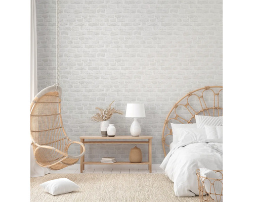 Helles Schlafzimmer mit Rattanmöbeln und Backsteinwand